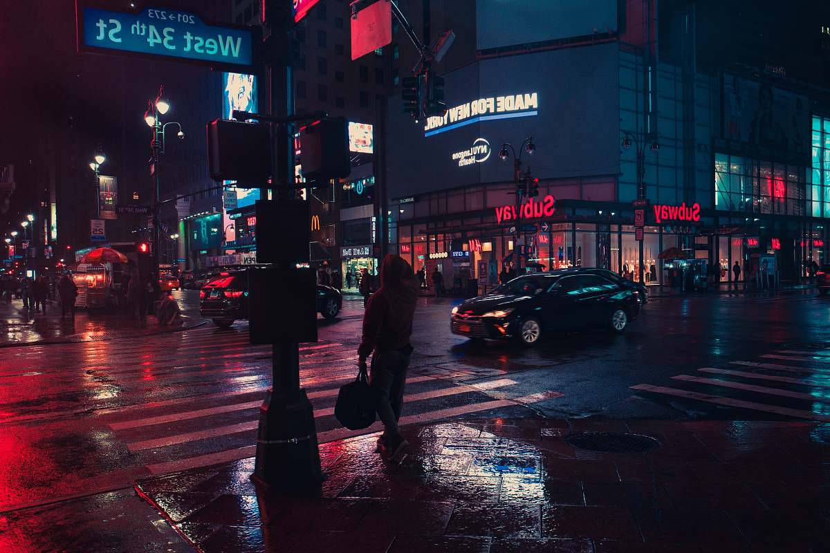 city person standing beside traffic light during night urban